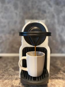 eine Kaffeemaschine schüttet Kaffee in eine Tasse in der Unterkunft OliVISTA - Live in Nature in Astris