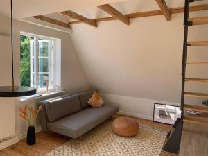 a living room with a couch and a window at Ostseeloft in Flensburg