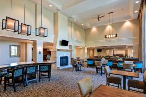 a lobby of a hotel with tables and chairs at Homewood Suites by Hilton Aurora Naperville in Aurora