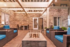 a patio with wicker furniture and a brick wall at Homewood Suites by Hilton Pleasant Hill Concord in Pleasant Hill