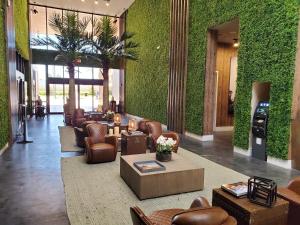 a lobby with couches and chairs and plants at 7564 Magic Village luxury jacuzzi bbq 6min Disney & 192 in Orlando