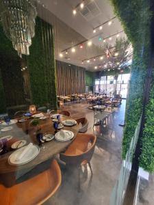 a dining room with tables and chairs and plants at 7564 Magic Village luxury jacuzzi bbq 6min Disney & 192 in Orlando