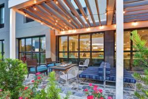 un patio al aire libre con sillas, mesas y luces en Home2 Suites Pensacola I-10 At North Davis Hwy, en Pensacola