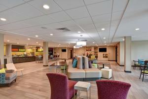 a lobby of a hospital with a couch and chairs at Home2 Suites Pensacola I-10 At North Davis Hwy in Pensacola