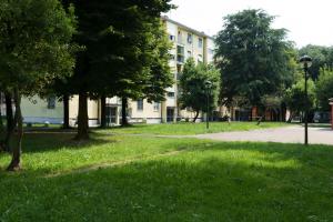 een gebouw in een park met gras en bomen bij DUOMO-LINATE, Casa con Parcheggi Gratis e Tram a 100m in Milaan