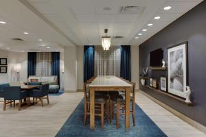 Hampton Inn Fort Lauderdale Pompano Beach في بومبانو بيتش: غرفة معيشة مع طاولة وغرفة طعام