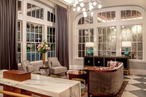 a living room with a table and chairs and windows at The Virginian Lynchburg, Curio Collection By Hilton in Lynchburg