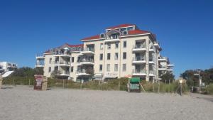 un gran edificio en la playa junto a la arena en Ferienwohnung Fehmarn am Südstrand en Fehmarn