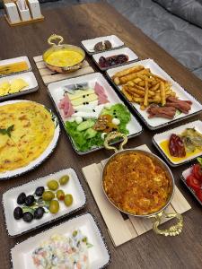 una mesa con diferentes tipos de comida en platos en TRABZON Asel Suite Otel, en Trabzon