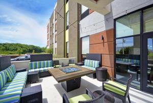 eine Terrasse mit einem Tisch und Stühlen sowie ein Gebäude in der Unterkunft Home2 Suites By Hilton Dallas Desoto in DeSoto