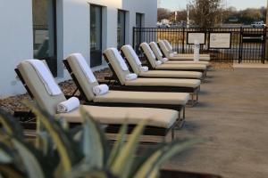 eine Reihe von Stühlen neben einem Gebäude in der Unterkunft Hilton Garden Inn Austin Airport in Austin