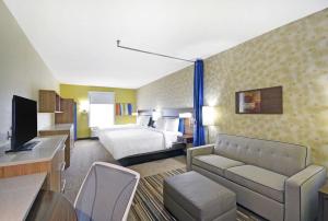 a hotel room with a bed and a living room at Home2 Suites By Hilton Dallas Desoto in DeSoto