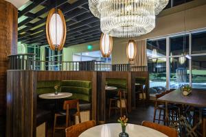 a restaurant with tables and chairs and a chandelier at Hilton Garden Inn Wausau, WI in Wausau