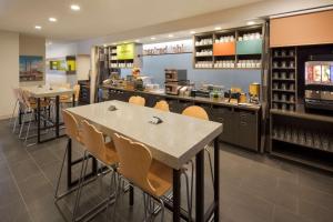 un ristorante con bancone, tavoli e sedie di Home2 Suites By Hilton Mishawaka South Bend a Mishawaka