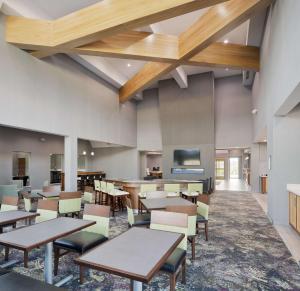 a cafeteria with tables and chairs and a bar at Homewood Suites By Hilton Topeka in Topeka