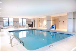 a large swimming pool with blue water in a building at Hampton Inn & Suites Big Rapids, Mi in Big Rapids