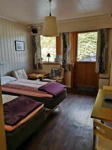 a bedroom with two beds and a living room at Kvamsdal Pensjonat 3 in Eidfjord