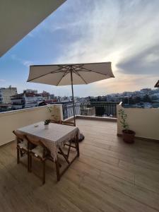 a table and an umbrella on a balcony at Sunset rooftop apartment in Thessaloniki