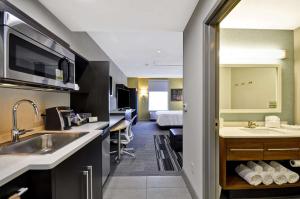 蒙特朱丽叶Home2 Suites By Hilton Mt. Juliet, Tn的带水槽的厨房和1间带床的房间