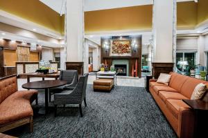 een lobby met een bank, tafels en een open haard bij Hilton Garden Inn San Marcos in San Marcos