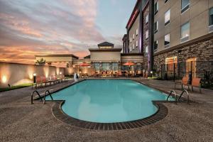 a large swimming pool in front of a building at Hilton Garden Inn San Marcos in San Marcos