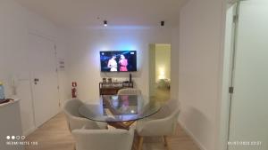 uma sala de jantar com mesa e cadeiras de vidro em Vista Mar em Viana do Castelo