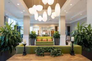 a lobby with a green couch and potted plants at Hilton Garden Inn Asheville Downtown in Asheville +62 photos