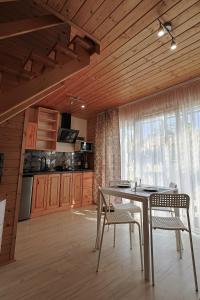 jadalnia ze stołem i krzesłami oraz kuchnia w obiekcie Aurora Ustka-Przewłoka w Ustce