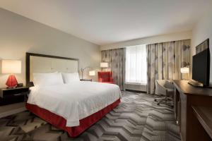 a hotel room with a bed and a flat screen tv at Hampton Inn by Hilton Spring Hill, TN in Kedron