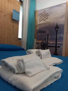 2 Betten mit weißen Handtüchern darüber in der Unterkunft Appartamento Nonna Lina in Padenghe sul Garda