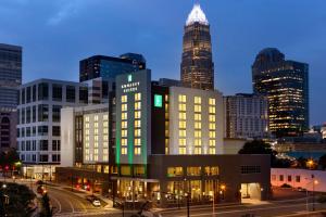 a lit up building in a city at night at Embassy Suites by Hilton Charlotte Uptown in Charlotte