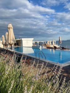 - une piscine avec des parasols et l'océan dans l'établissement Stylish apartment with sea view, à Petrčane