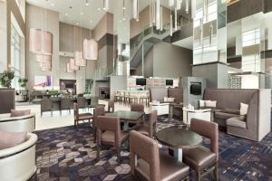 a lobby of a hotel with chairs and tables at Embassy Suites by Hilton Charlotte Uptown in Charlotte