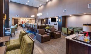 Hampton Inn & Suites Duluth North Mn في دولوث: مطعم فيه كراسي وطاولات وبار