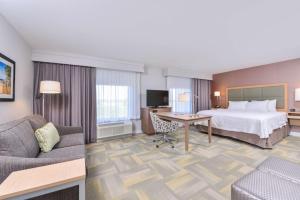 Hampton Inn and Suites Altoona-Des Moines by Hilton في ألتونا: غرفه فندقيه بسرير واريكه