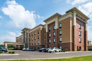 un grand bâtiment en briques avec des voitures garées dans un parking dans l'établissement Hampton Inn & Suites Wixom/Novi/Detroit, Mi, à Wixom