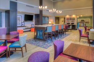 a restaurant with tables and chairs and a bar at Hampton Inn & Suites Wixom/Novi/Detroit, Mi in Wixom