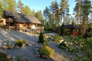 een blokhut met een tuinhuisje in het bos bij Holiday Villa Kerimaa 18 in Savonlinna