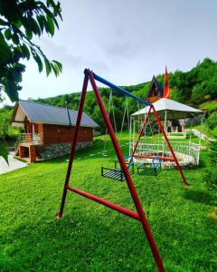 a swing set in a yard with a house at Vilat Pllumaj in Gropat e Selcës +80 photos