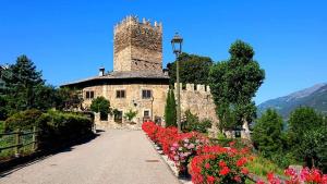 a building with a bunch of flowers in front of it at B&B La Tour de Villa in Aosta