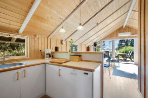 een keuken in een tiny house met een veranda bij Kildelodden14 in Ølsted