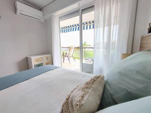 a bedroom with a bed and a view of a patio at Arrecife Beach in La Pineda