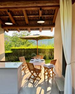 a patio with a table and chairs and an umbrella at MiaClara Relais in Alba