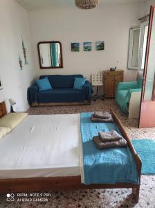 a bedroom with a large bed and a blue couch at Petrohori before midnight in Pylos
