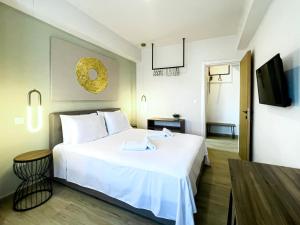 Pokój hotelowy z białym łóżkiem i telewizorem w obiekcie ATHONITE all seasons luxury suites w mieście Ierissós