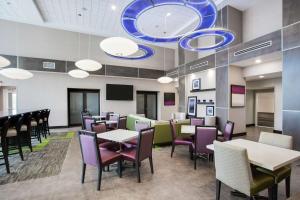 Hampton Inn and Suites Jacksonville/Orange Park, FL في أورانج بارك: غرفة طعام مع طاولات وكراسي