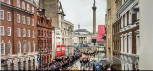 una multitud de personas caminando por una calle de la ciudad en Superb Apartment near Buckingham Palace, en Londres