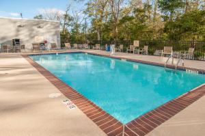 a swimming pool at a resort with tables and chairs at Hampton Inn Opelousas in Opelousas