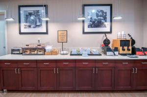 cocina con armarios marrones y encimera en Hampton Inn Opelousas, en Opelousas