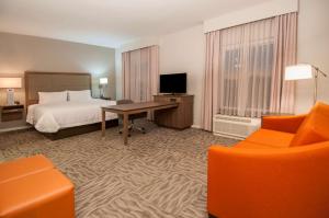 a hotel room with a bed and a desk and chair at Hampton Inn Opelousas in Opelousas